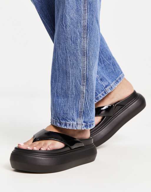 ASOS DESIGN Fiesty Zehenstegsandalen in Schwarz mit flacher Plateausohle ASOS