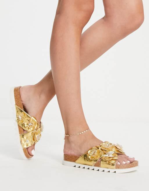 ASOS DESIGN – Figgy – Złote płaskie sandały ze skrzyżowanymi paskami z motywem kwiatów