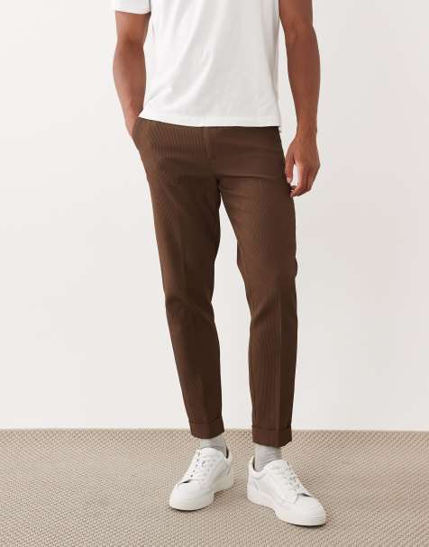 ASOS DESIGN – Figurbetonte, schmal zulaufende, bequeme Hose in Braun mit Rippenstruktur und Umschlag - view 1