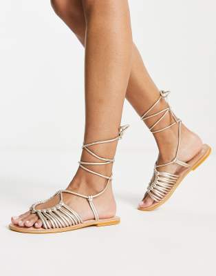 ASOS DESIGN - Fizz - Geknoopte platte leren sandalen met smalle bandjes in goud