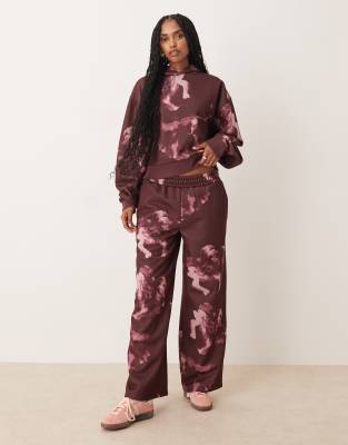 ASOS DESIGN - Gerade geschnittene Jogginghose in Pflaume mit duchgängigem Blumenmuster, Kombiteil-Lila