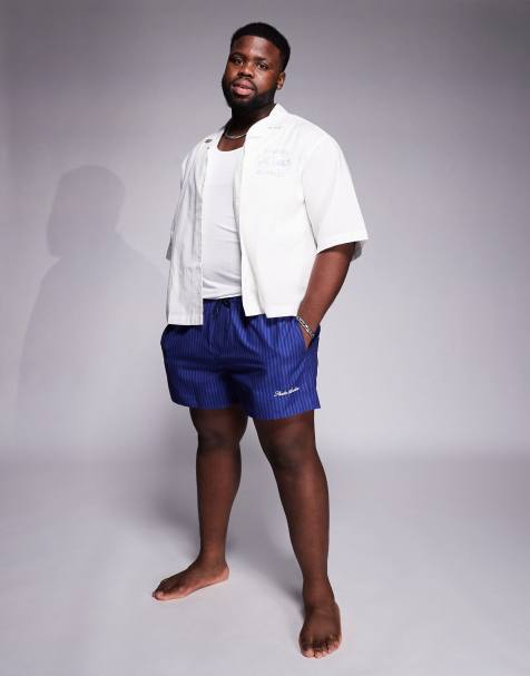 ASOS DESIGN – Gestreifte, kürzere Badeshorts in Marineblau mit platziertem Print - view 1