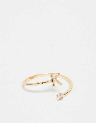 ASOS DESIGN - Goldfarbener Ring mit Wickeldesign, Zirkoniabesatz, „K"-Initiale und Geschenkbeutel
