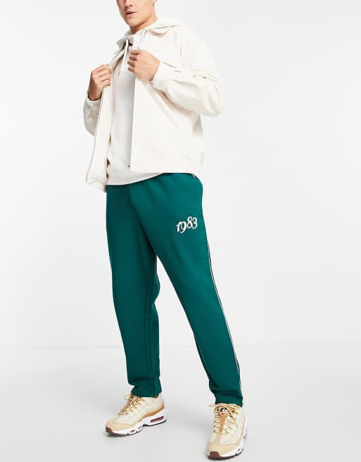 ASOS DESIGN – Gröna oversized mjukisbyxor med kantränder och broderad logga, del av set