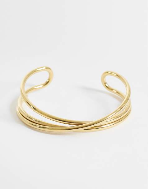 ASOS DESIGN – Guldfärgat manschettarmband i vattentåligt, rostfritt stål med korsad design - view 1