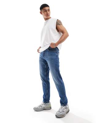 ASOS DESIGN stretch tapered jeans in mid wash blue - ASOS Price Checker