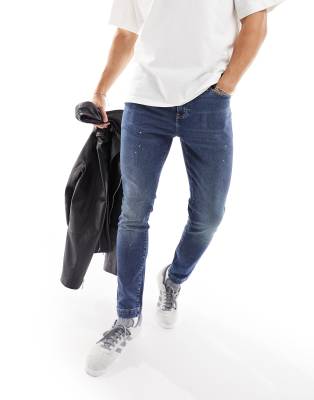 ASOS DESIGN - Jean skinny à détails taches de peinture - Bleu moyen délavé