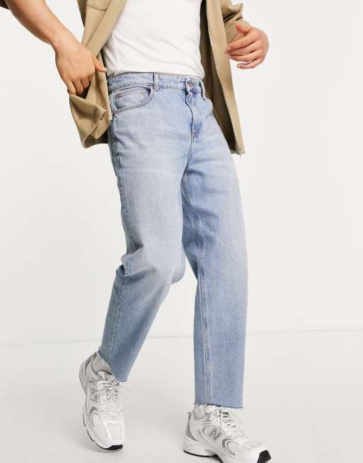 ASOS DESIGN - Jeans comodi affusolati lavaggio chiaro con fondo grezzo 