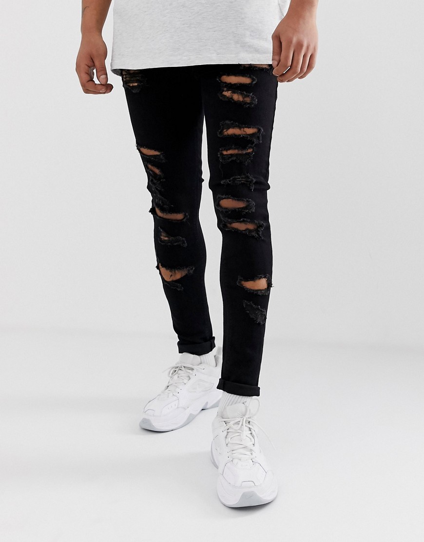 ASOS DESIGN - Jeans effetto spray in denim power stretch nero con strappi vistosi