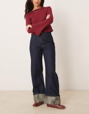 ASOS DESIGN - Jeans in Indigoblau mit Saumaufschlag und Leopardenprint