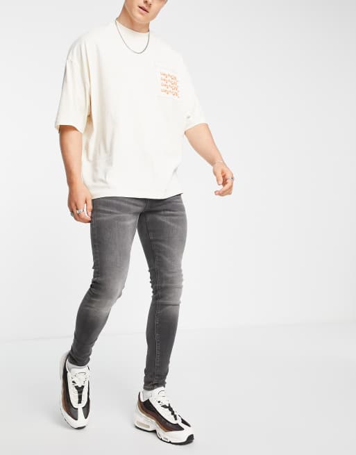 ASOS DESIGN - Jeans in power stretch nero slavato effetto spray 