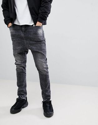 ASOS DESIGN - Jeans met laag kruis in zwart met scheuren en onafgewerkte zoom