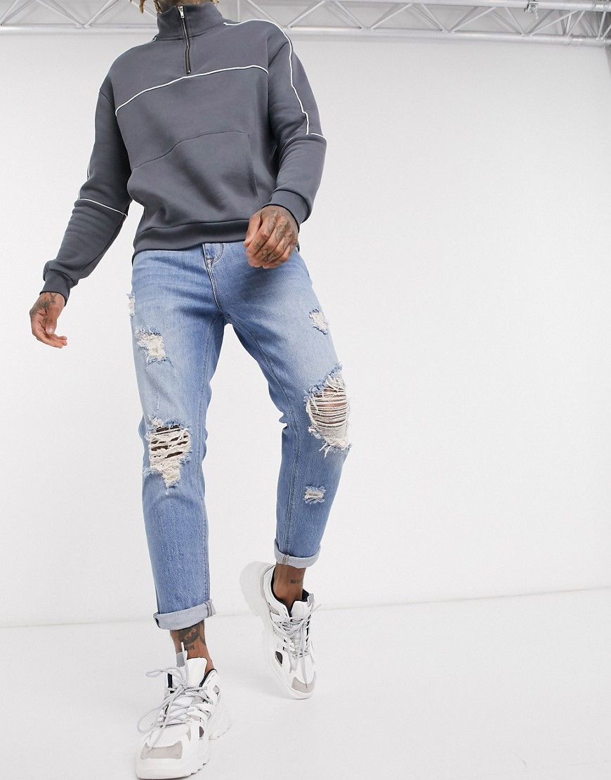 ASOS DESIGN - Jeans met smaltoelopende pijpen, grote scheuren en lichte vintage wassing-Blauw