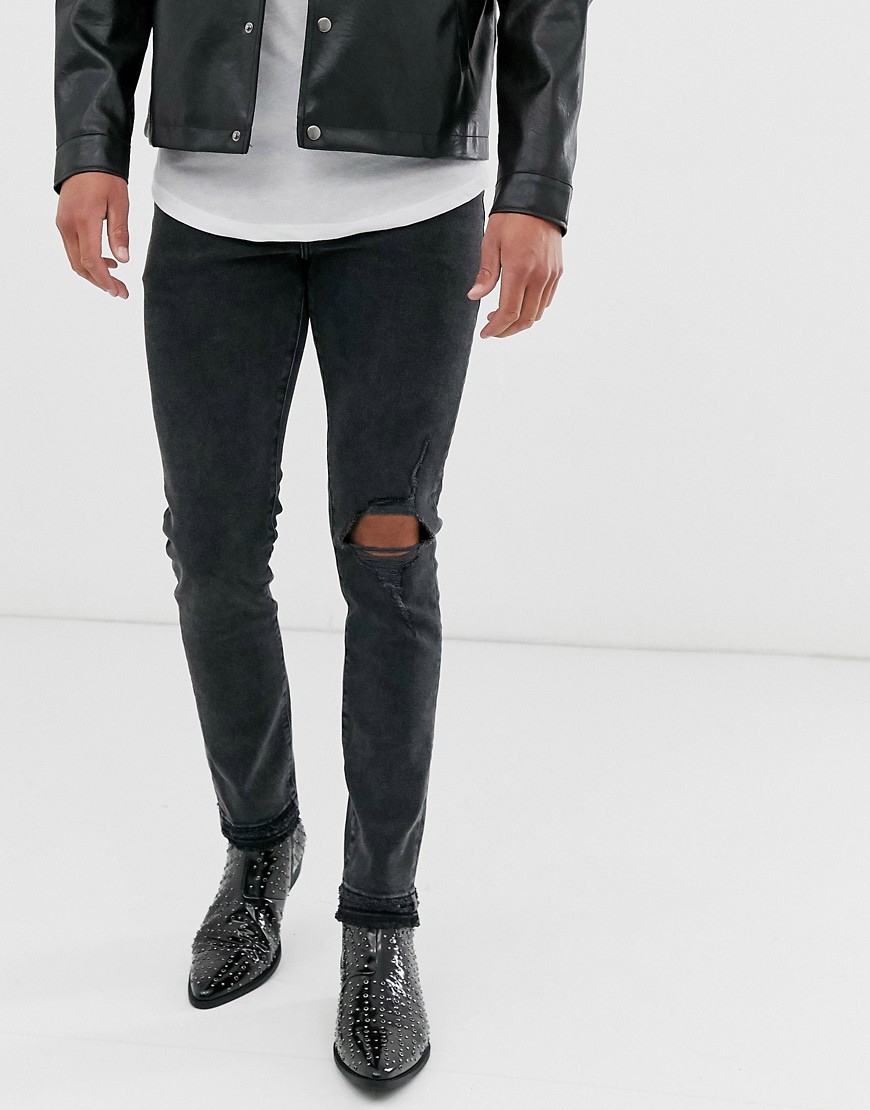ASOS DESIGN - Jeans skinny 12,5 oz nero slavato con strappi sulle ginocchia e fondo consumato