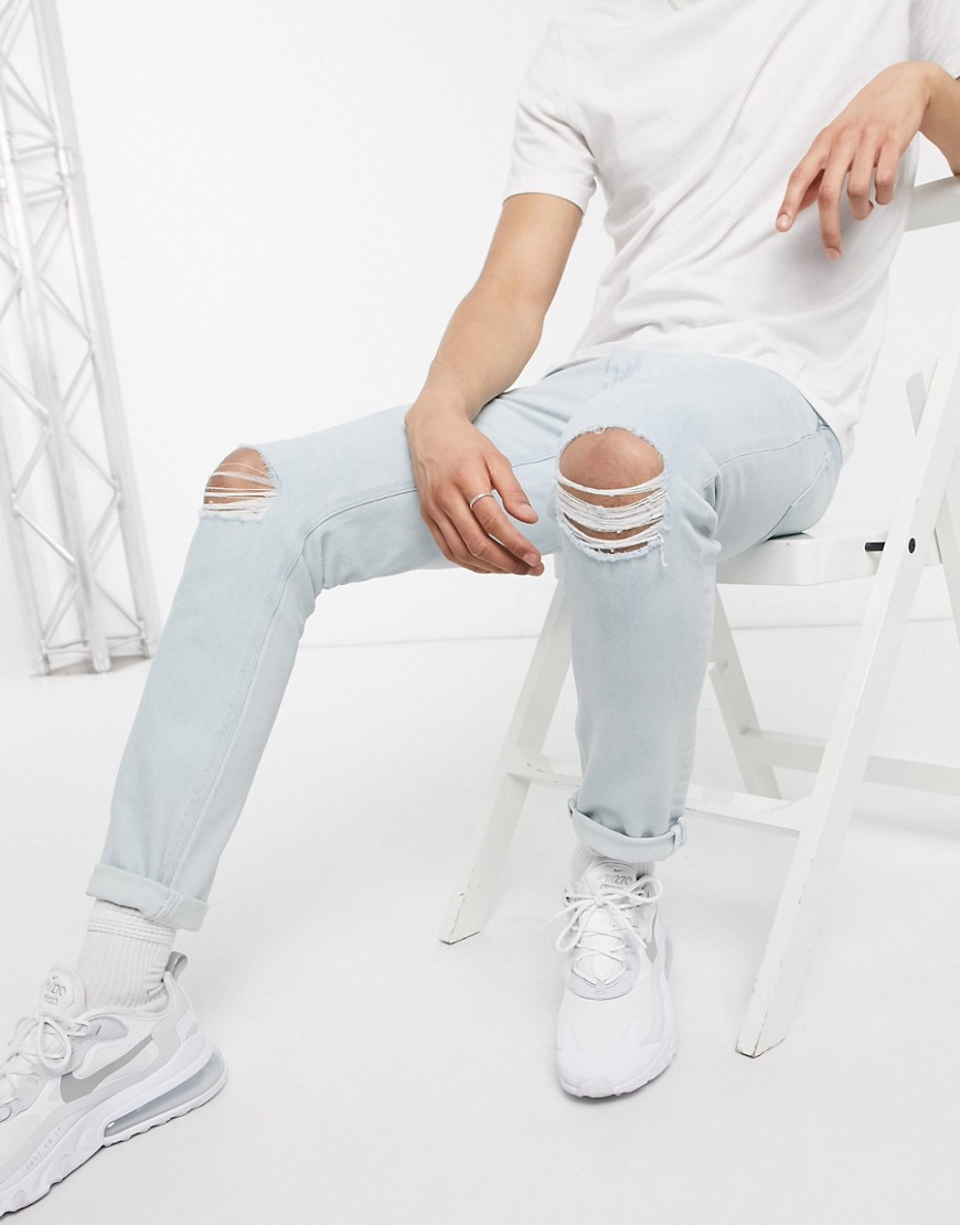 ASOS DESIGN - Jeans stretch slim a lavaggio chiaro con strappi al ginocchio-Blu