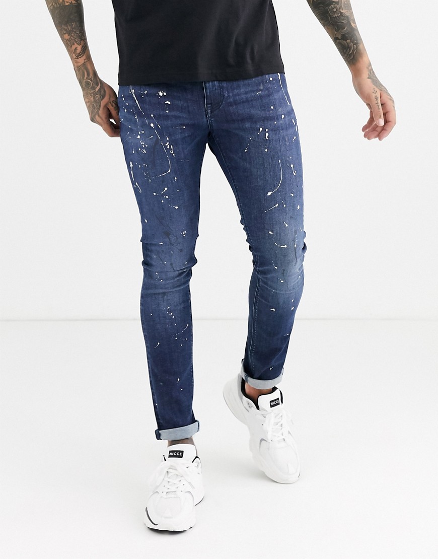 ASOS DESIGN - Jeans super skinny lavaggio scuro blu con stampa a schizzi di vernice