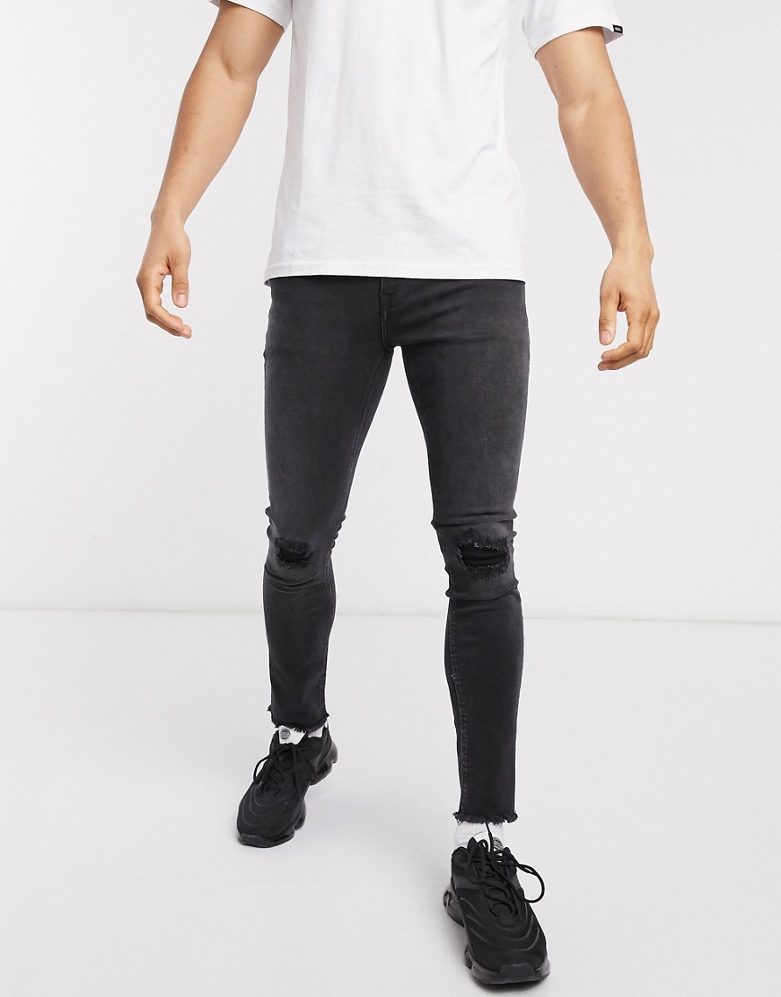 ASOS DESIGN - Jeans super skinny nero slavato con strappi e fondo grezzo