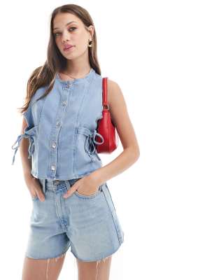 ASOS DESIGN - Jeansweste in gebleichtem Farbton mit Schleifenverzierung-Blau