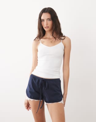 ASOS DESIGN jersey shorts with lace under layer in navy