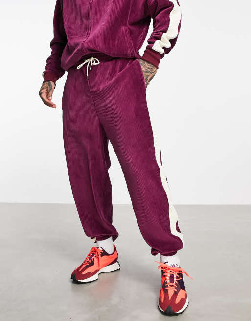 ASOS DESIGN - Joggers oversize bordeaux in velour a coste con righe laterali in coordinato