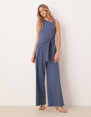 ASOS DESIGN - Jumpsuit in Marineblau mit Wickeldesign und asymmetrischer Verzierung am Träger in Flüssiggold-Optik