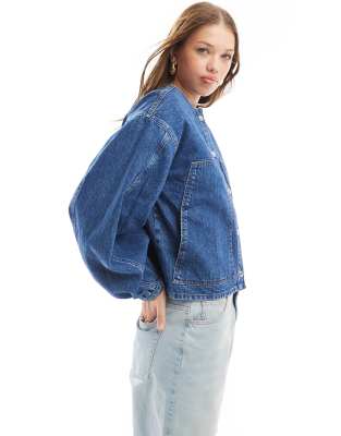 ASOS DESIGN - Kragenlose Jeansjacke in indigoblauer Waschung mit Ballonärmeln