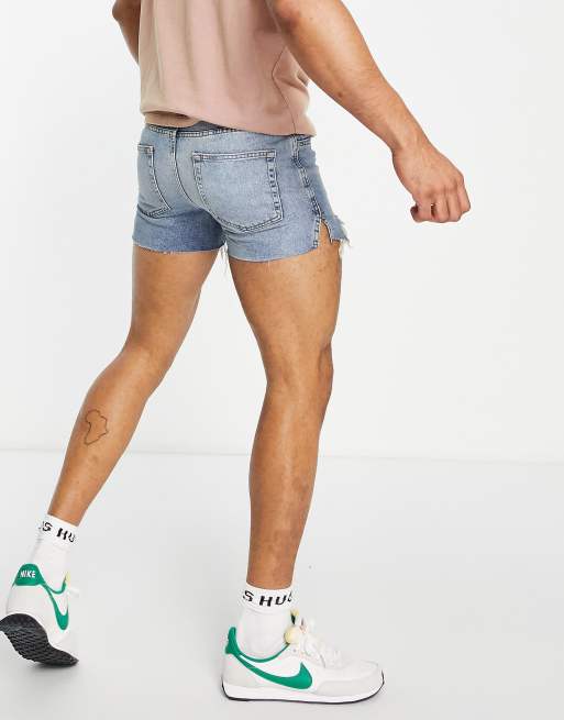 ASOS Design Kurzere Jeansshorts in mittelblauer Waschung im Stil der 90er mit Zierrissen und unversaubertem Saum ASOS