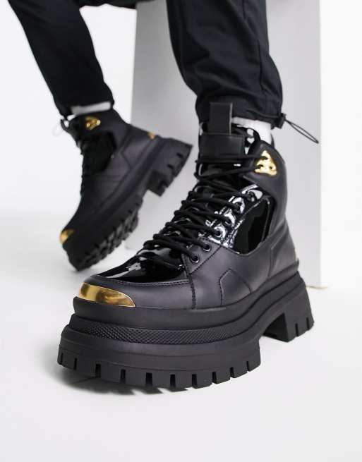 ASOS DESIGN lace up boot in black faux leather with gold detail on chunky sole