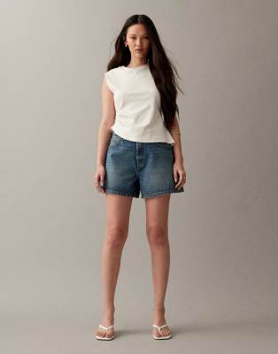 ASOS DESIGN - Längere Jeans-Shorts in Vintage-Blau mit A-Linien-Schnitt