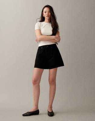 ASOS DESIGN - Längere Jeansshorts in Schwarz mit A-Linien-Schnitt