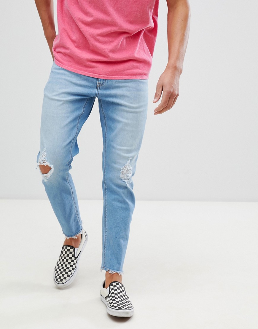 ASOS DESIGN – Ljusblå avsmalnande jeans med stretch och slitna detaljer