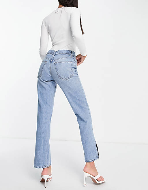 Women low rise straight leg jeans in midwash with split hem 
