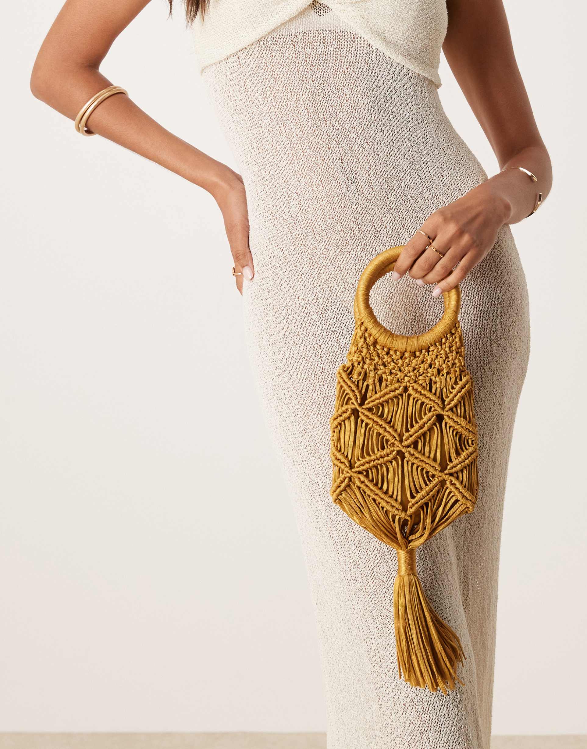 asos design macrame clutch with tassel detail in gold