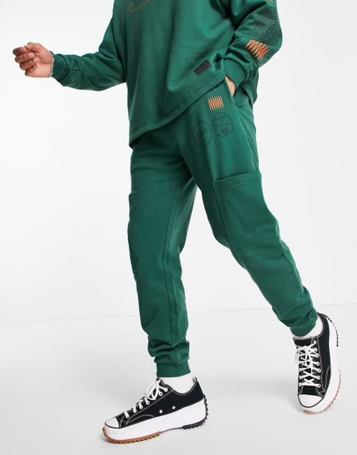 ASOS DESIGN matching tapered joggers with cargo pockets and multi placement outdoors prints