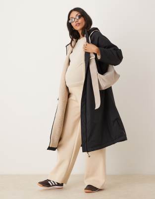 ASOS DESIGN Maternity - Longline-Regenmantel in Schwarz mit Fleece-Futter, Umstandsmode