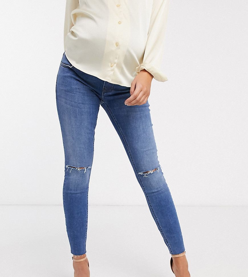 ASOS DESIGN Maternity Ridley high waisted skinny jeans in mid wash blue with rips with over the bump band