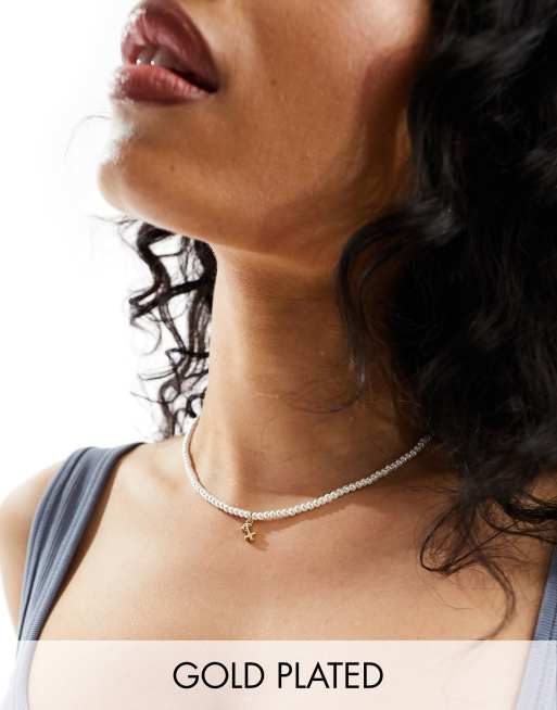 ASOS DESIGN - Met 14k goud vergulde ketting met imitatieparels van glas en sterrenbeeld hangertje met Boogschutter symbool, verpakt in cadeauzakje