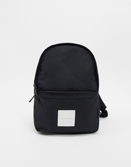 ASOS DESIGN Unrivalled Supply mini backpack in black with branded patch