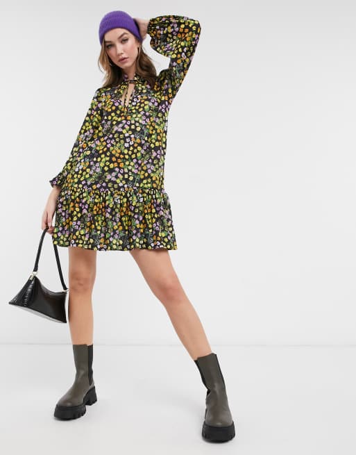 ASOS DESIGN mini smock dress with pep hem and tie neck detail in black based floral