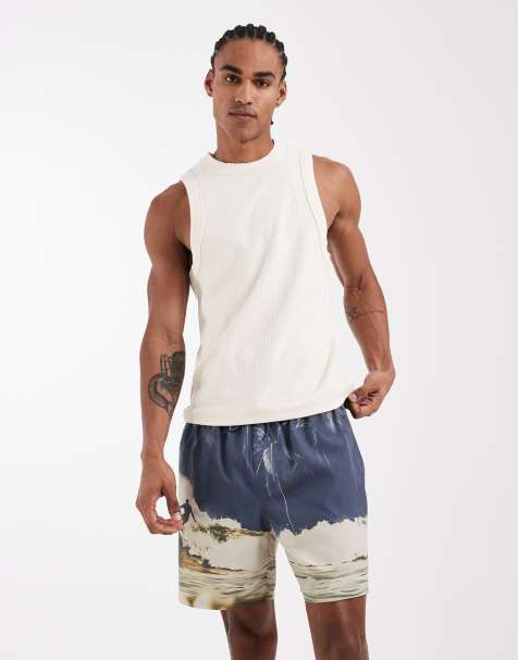 ASOS DESIGN – Mittellange Badeshorts in Blau mit Surfer-Muster - view 1