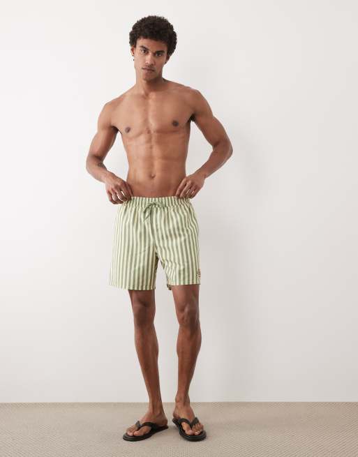 ASOS DESIGN – Mittellange, gestreifte Badeshorts in Gelb und Grün mit gesticktem Aufnäher, 3 von 5