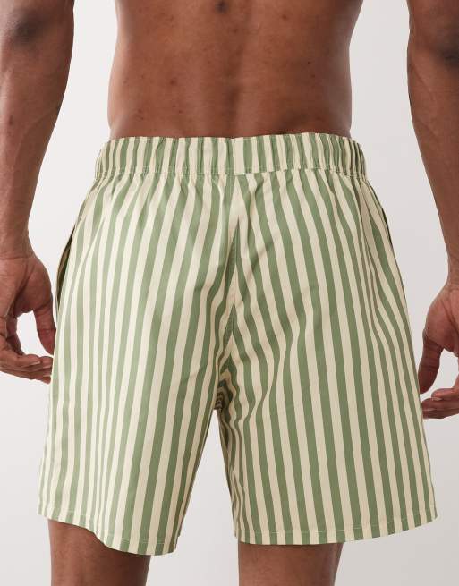 ASOS DESIGN – Mittellange, gestreifte Badeshorts in Gelb und Grün mit gesticktem Aufnäher, 4 von 5