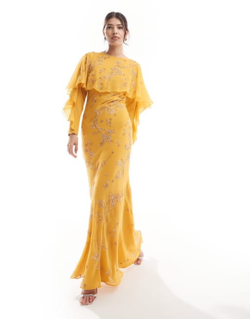 ASOS DESIGN – Modesty – Musztardowa zdobiona sukienka maxi ze skosu z długimi rękawami, falbanką i pelerynką 