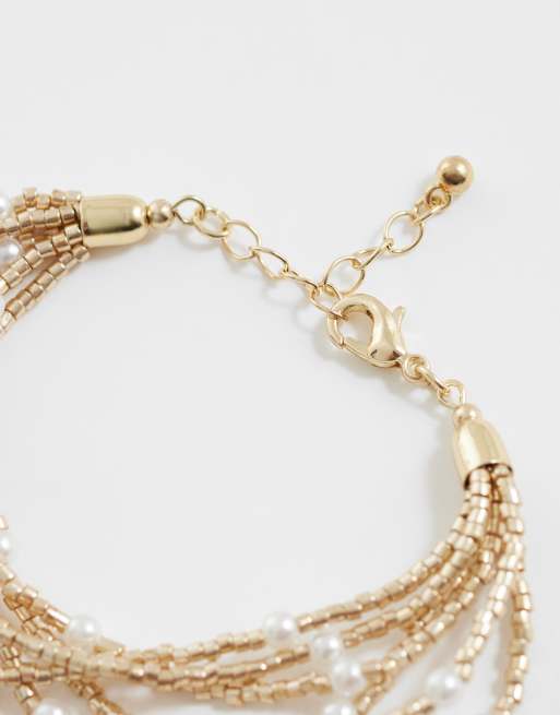 ASOS DESIGN multi-row bracelet with bead and faux pearl design in gold tone, 2 of 3