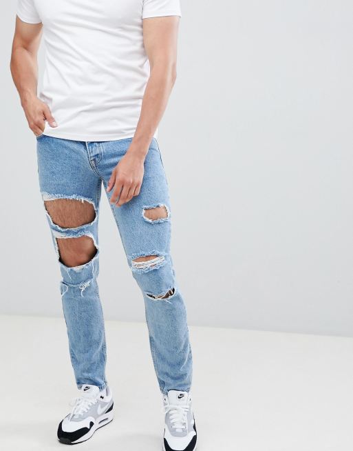 ASOS DESIGN – Niebieskie dopasowane jeansy z dużymi rozdarciami