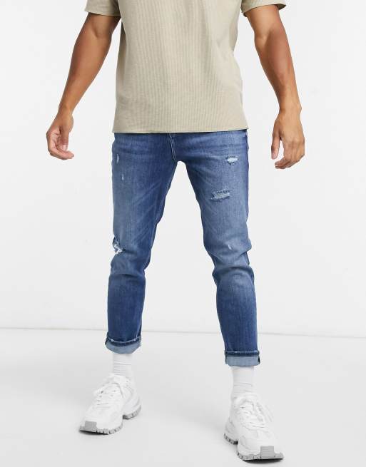 ASOS DESIGN – Niebieskie jeansy o marchewkowym kroju ze zwężanymi nogawkami z przetarciami