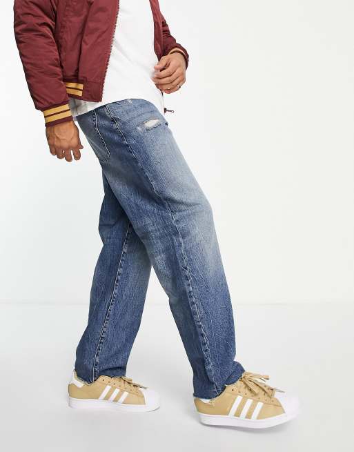 ASOS DESIGN – Niebieskie workowate jeansy z barwionego ciemnoniebieskiego denimu z przetarciami