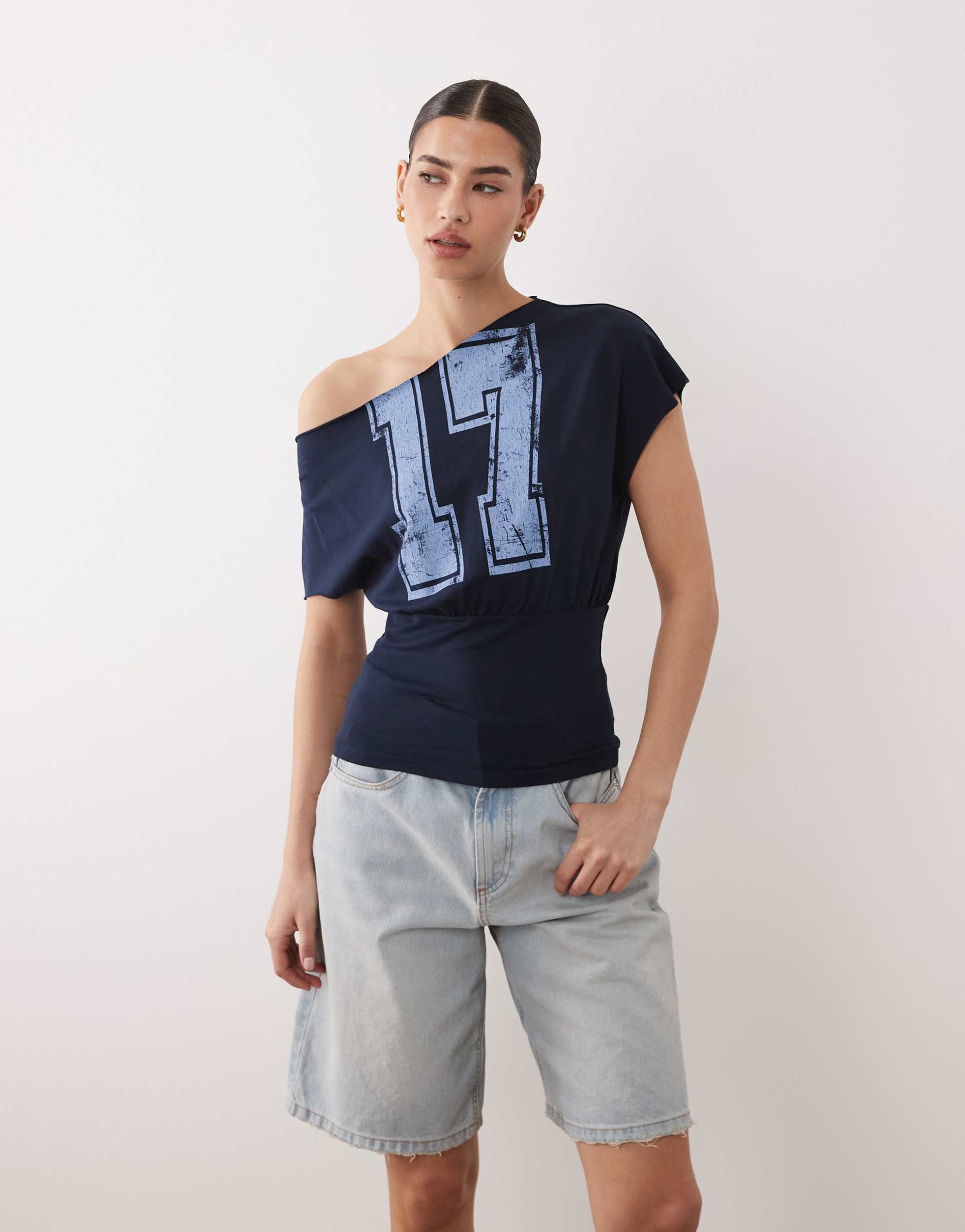 asos design off shoulder cinched waist t-shirt with varsity number graphic in navy