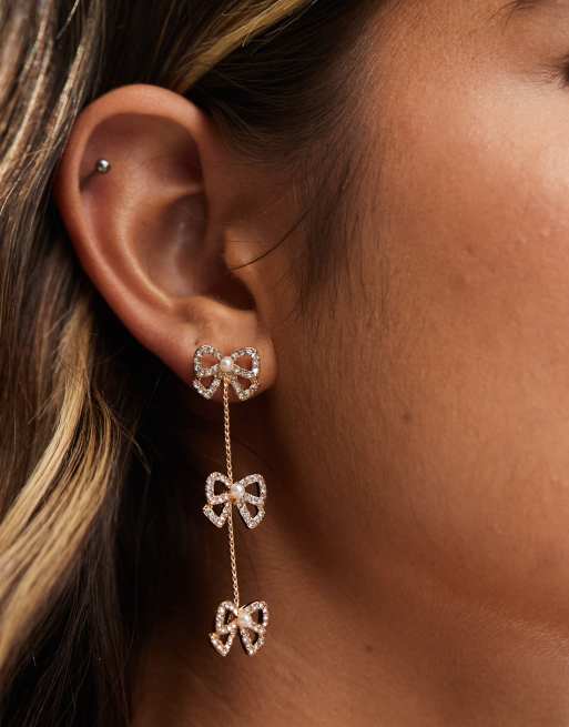 ASOS DESIGN - Orecchini pendenti color oro con fiocco piccolo e catenina