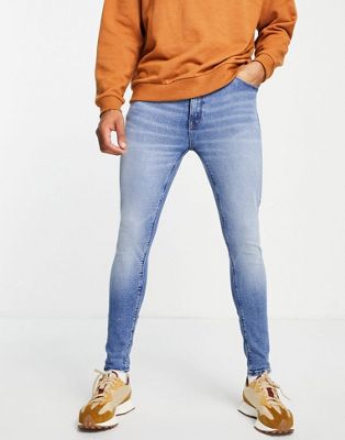ASOS DESIGN spray on jeans with powerstretch in mid wash blue